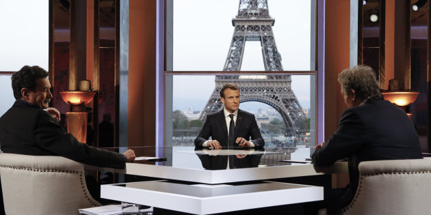 French President Emmanuel Macron poses on the TV set before an interview with RMC-BFM journalist Jean-Jacques Bourdin and Mediapart investigative website journalist Edwy Plenel, at the Theatre National de Chaillot across from the Eiffel Tower in Paris